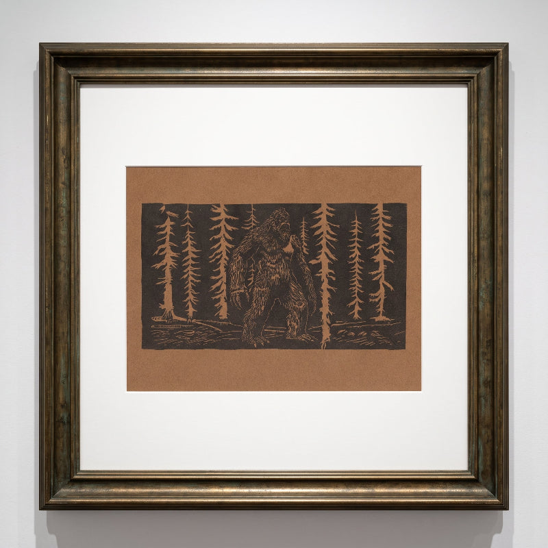 Bigfoot linocut print in a forest on dark brown paper, limited edition folklore artwork