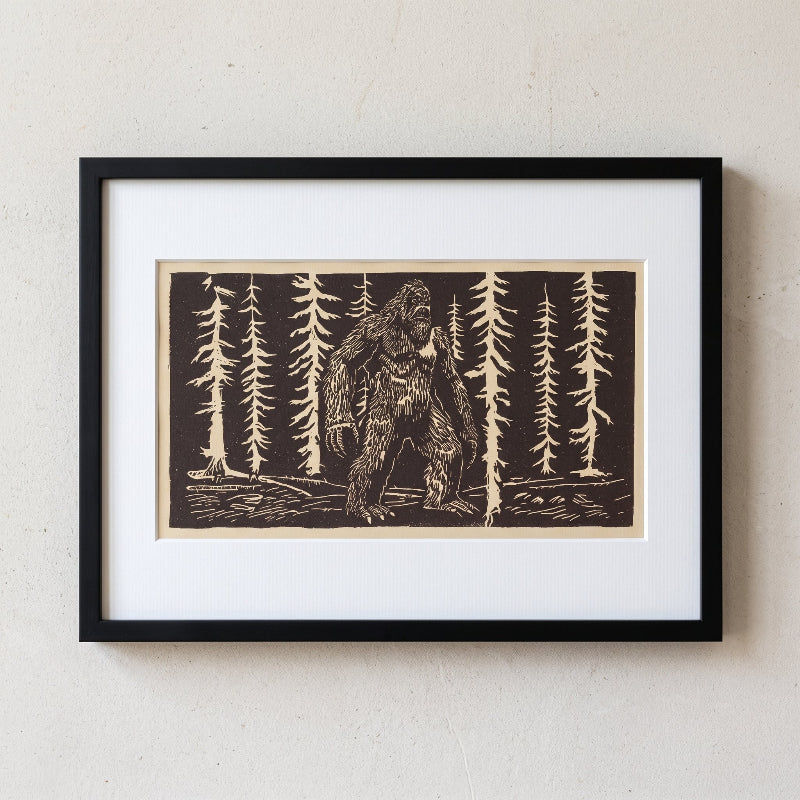 Bigfoot linocut print in a forest on light brown paper, limited edition folklore artwork