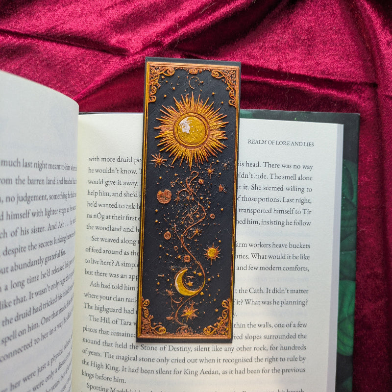 Celestial Balance bookmark with raised sun, crescent moon, stars, and ornate gold details