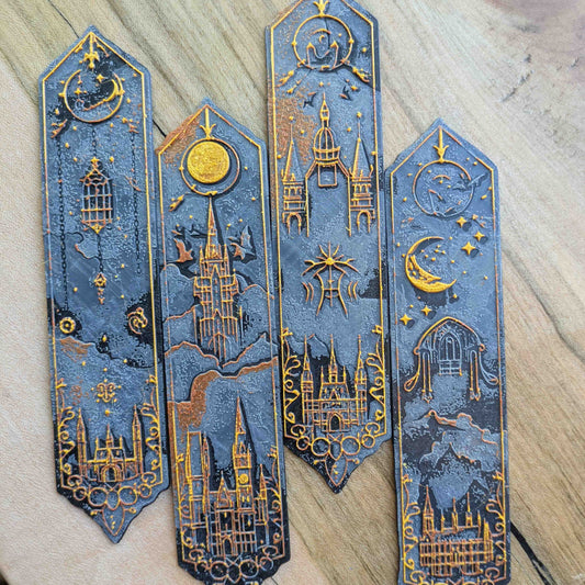 Set of 4 celestial and gothic-themed bookmarks in black and gold with moon, stars, and castle designs.