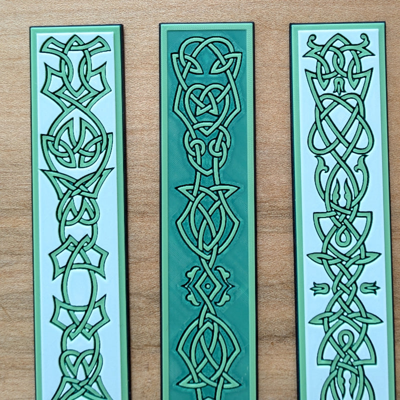 Three textured Celtic bookmarks displayed together featuring unique medieval-inspired knotwork designs.