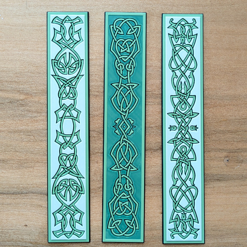 Close-up showing the raised textured Celtic knotwork across the three bookmark designs.