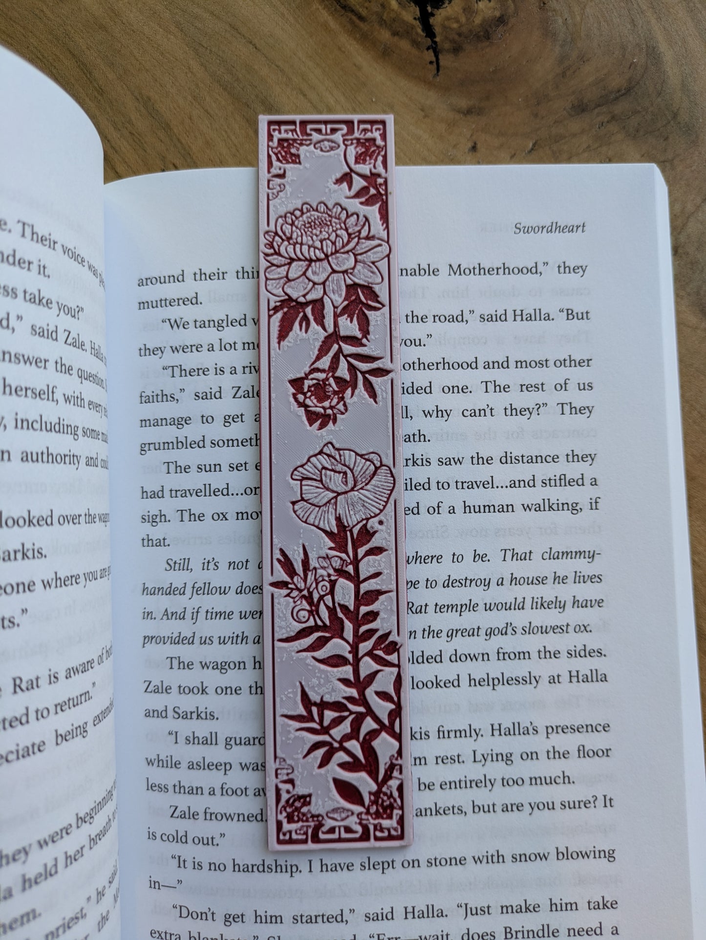 A bookmark featuring intricate red floral blossoms