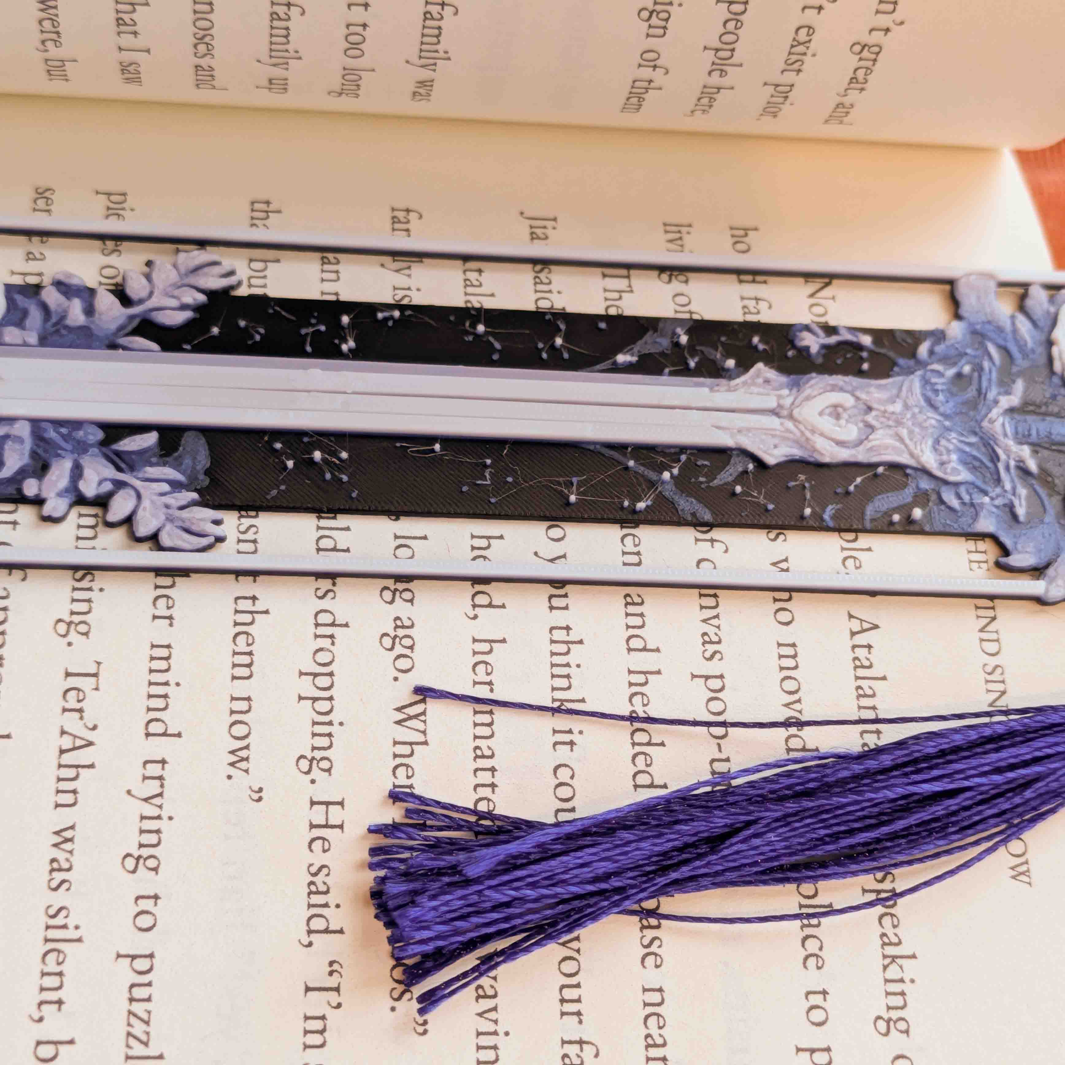 Close-up of floral sword artwork and ornamental details on a long fantasy bookmark