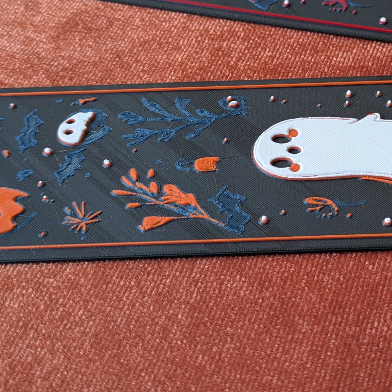 Close-up showing the detailed botanical artwork and ghost illustration on the Ghost Garden bookmark.