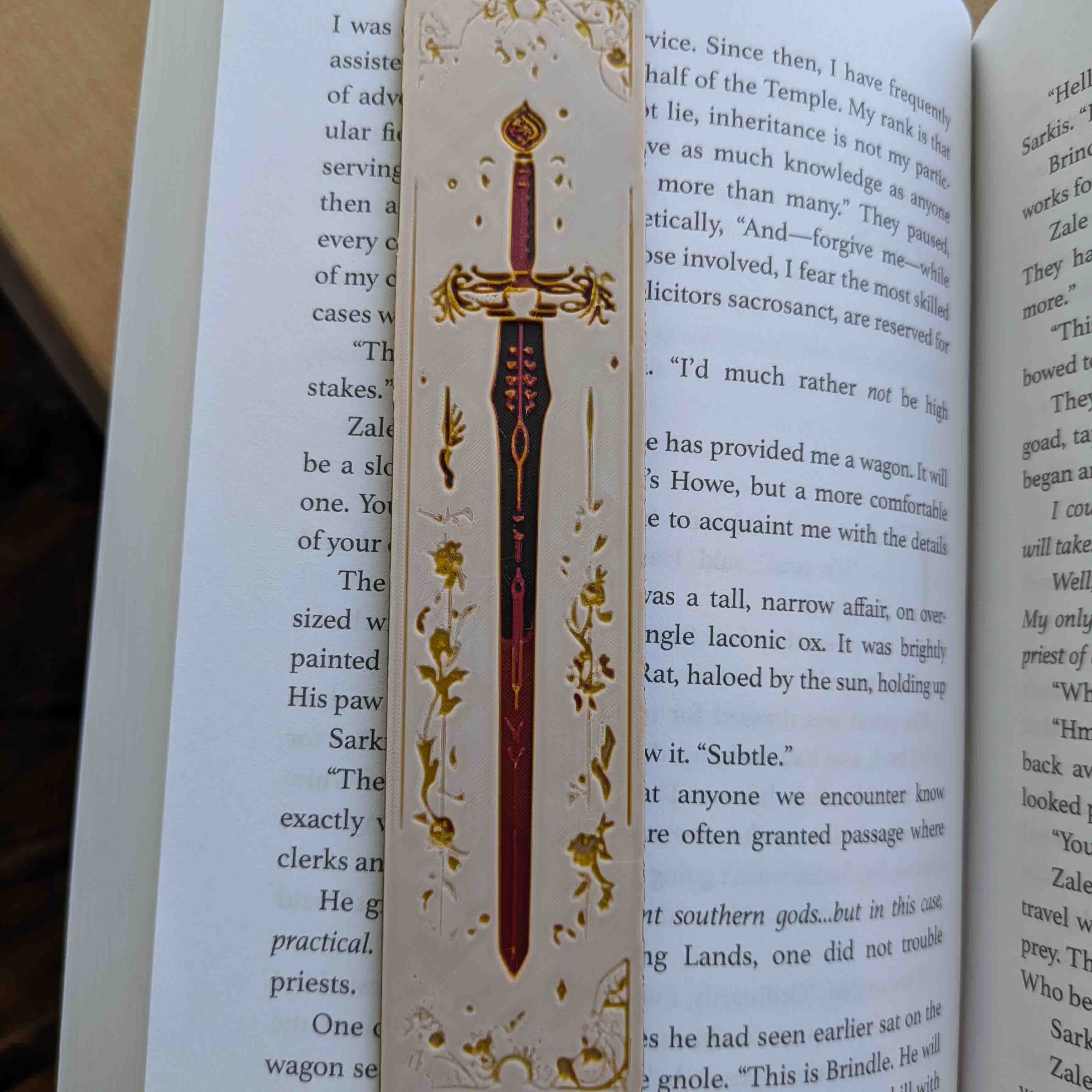 Ivory Lumina Sword Bookmark showcasing a white and gold sword design with gothic detailing on an ivory background.