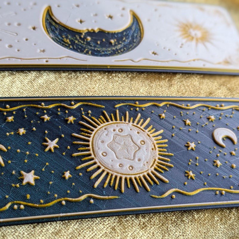 Close-up detail comparison of gold embossing across three celestial bookmark designs
