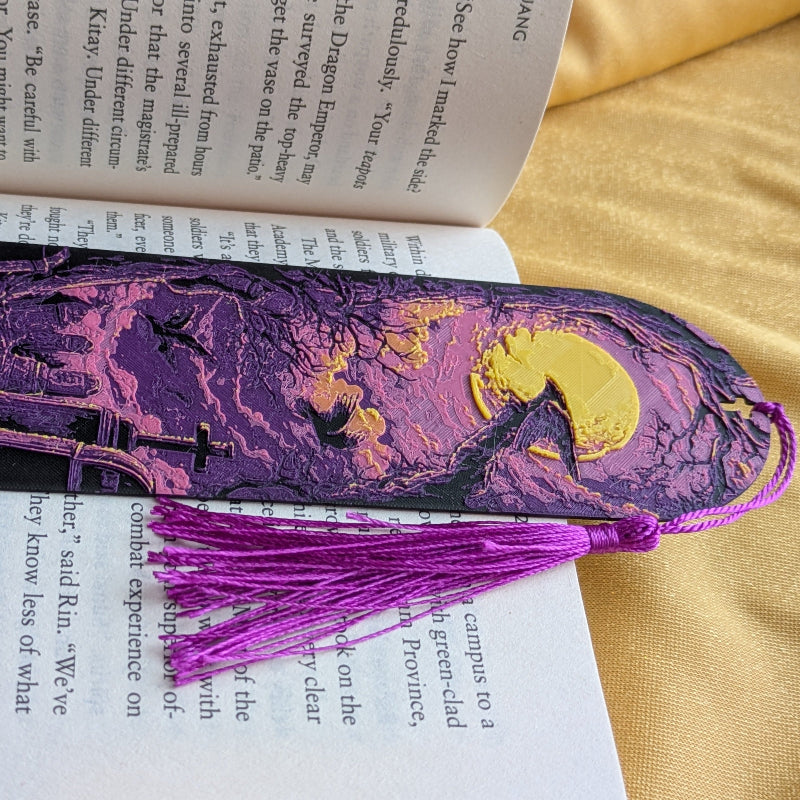 Close-up of textured purple bookmark surface showing layered moonlit graveyard artwork and print detail