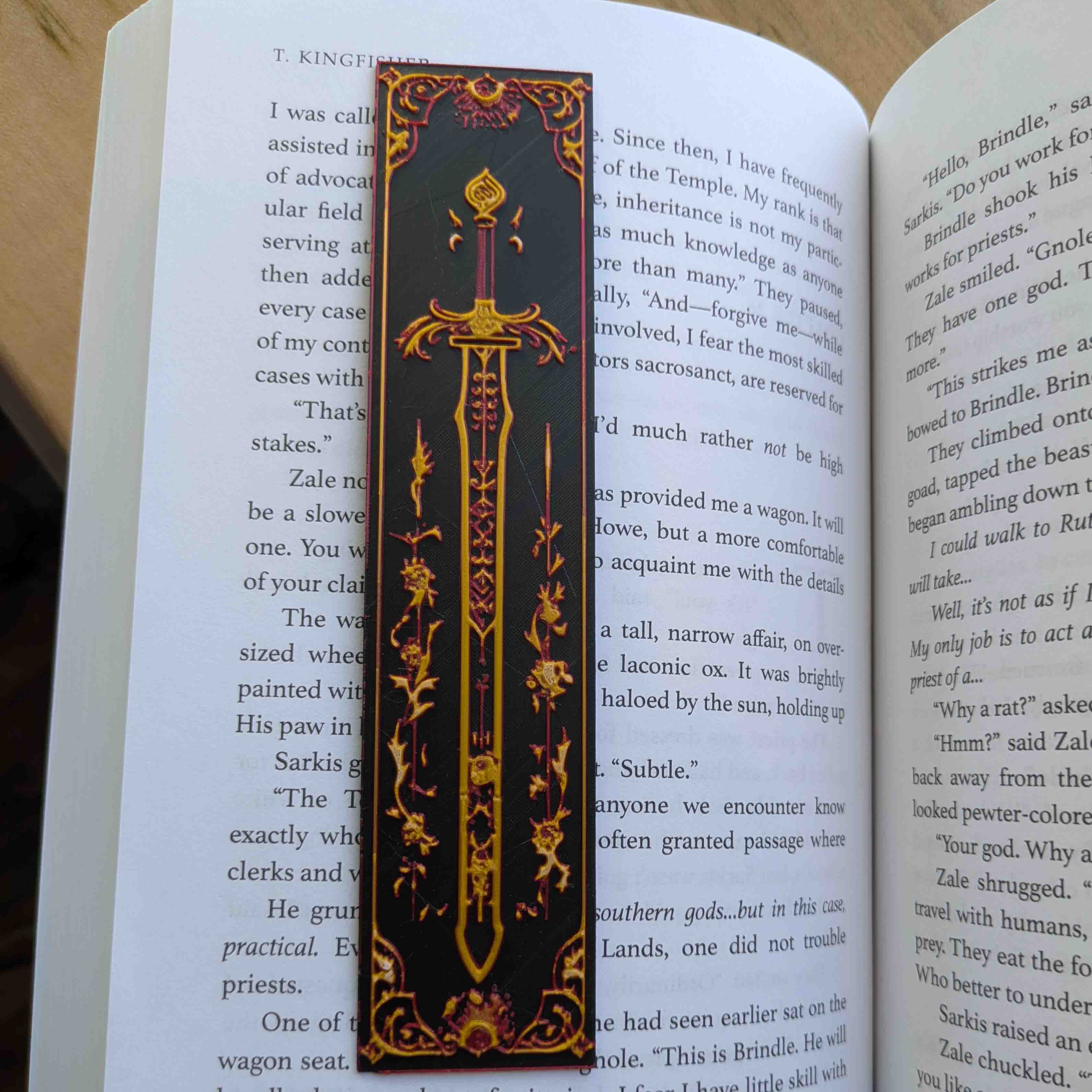 Obsidian Nocturne Sword Bookmark with a gold sword on a black background framed by gothic floral and celestial accents.