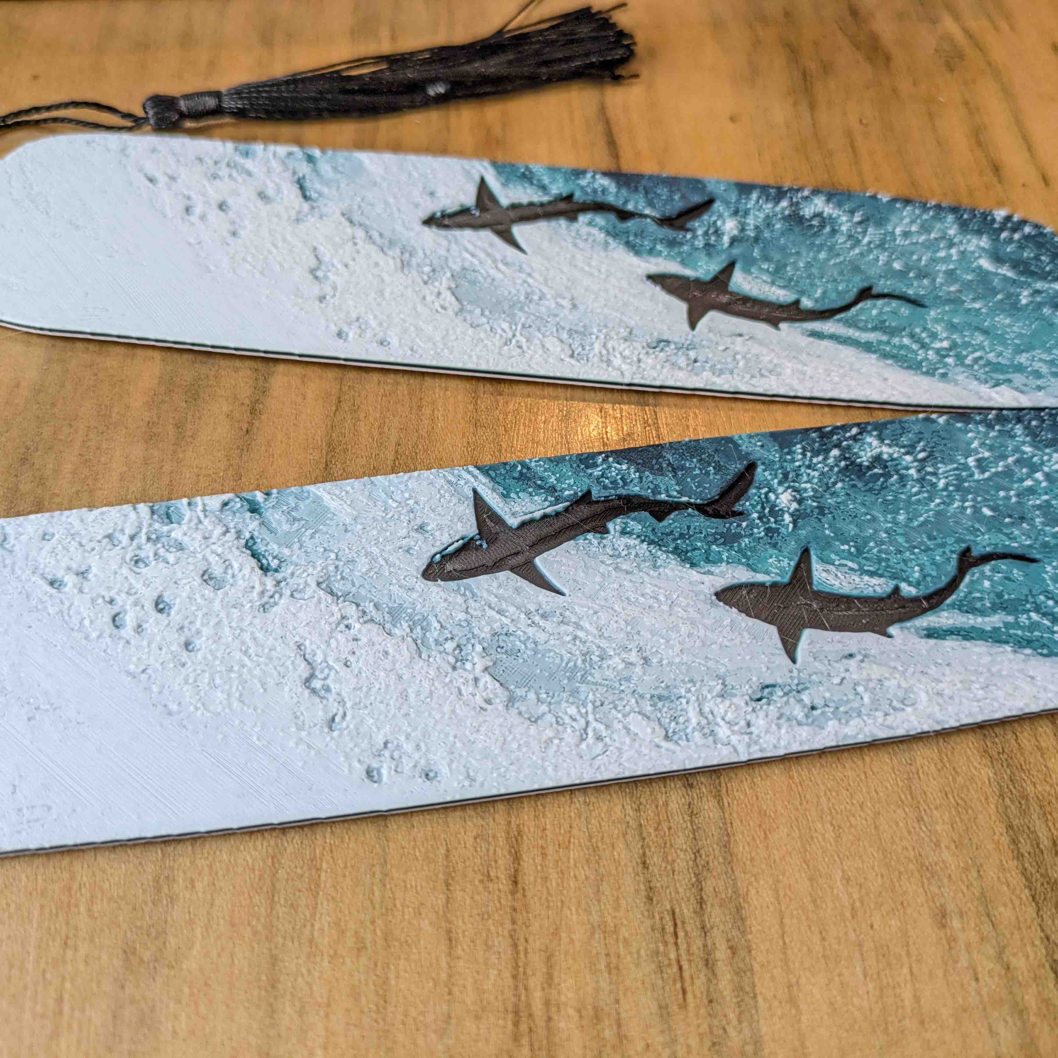 Close-up of textured ocean wave artwork and shark silhouettes