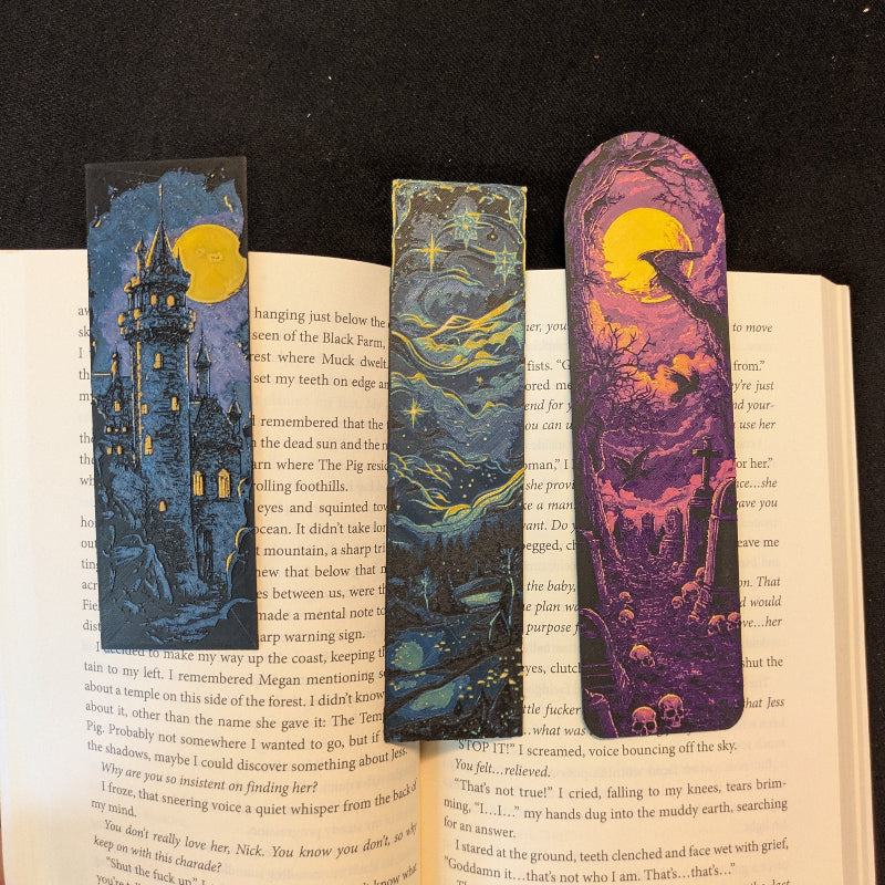 Close-up of the One More Chapter Bundle showing detailed artwork on the Starry Night Sky, Moonlit Castle I, and Moonlit Graveyard bookmarks