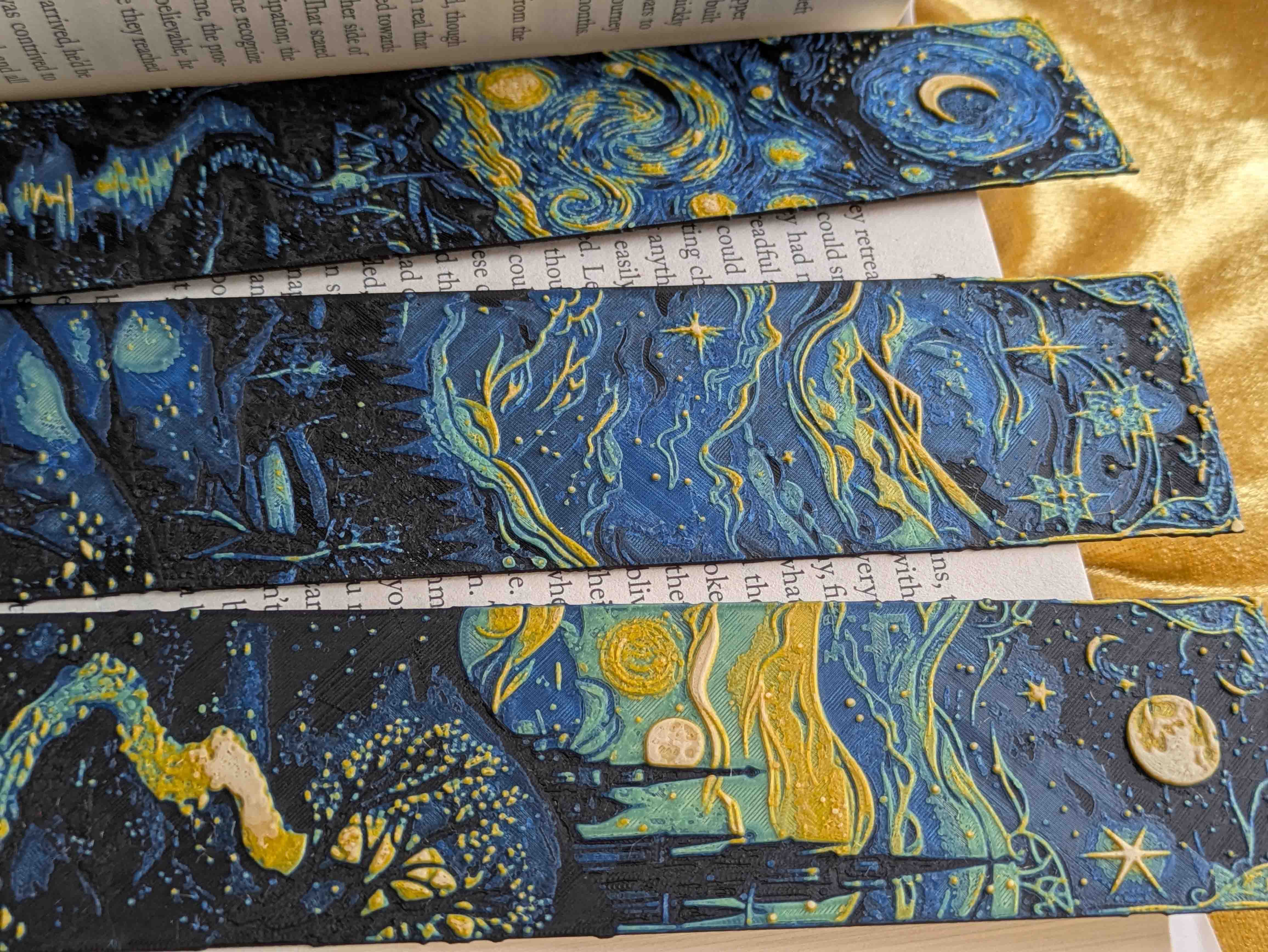 Close-up detail of three Starry Night inspired bookmarks showing spiral sky, flowing stars, and moonlit landscape designs