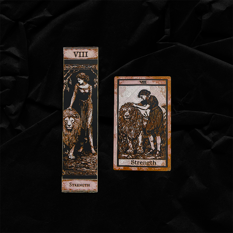 Strength tarot bookmarks, Classic and Collector Editions, shown side by side against a black fabric background