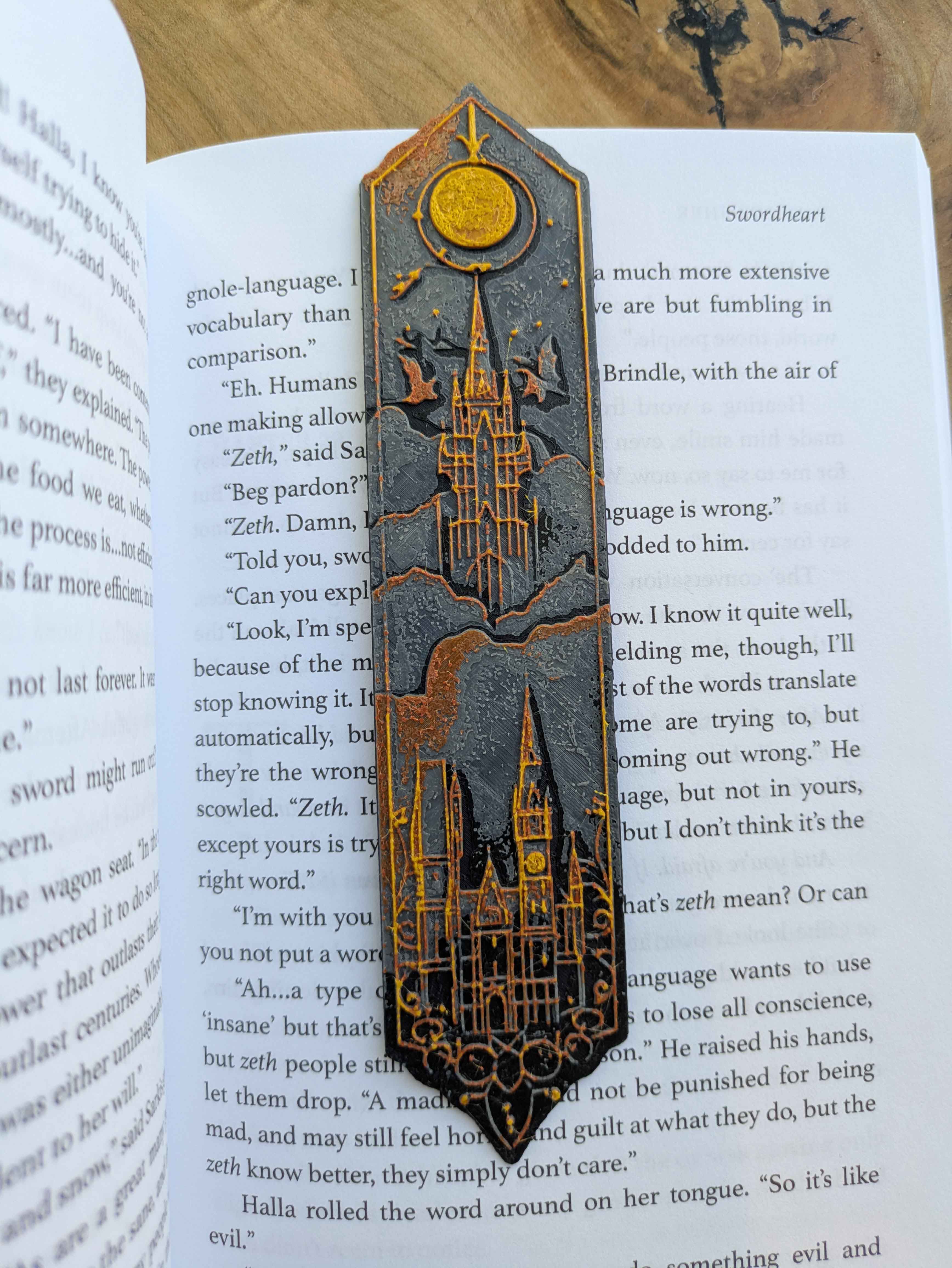 Handcrafted black bookmark with gold accents featuring a sunburst and castle design.