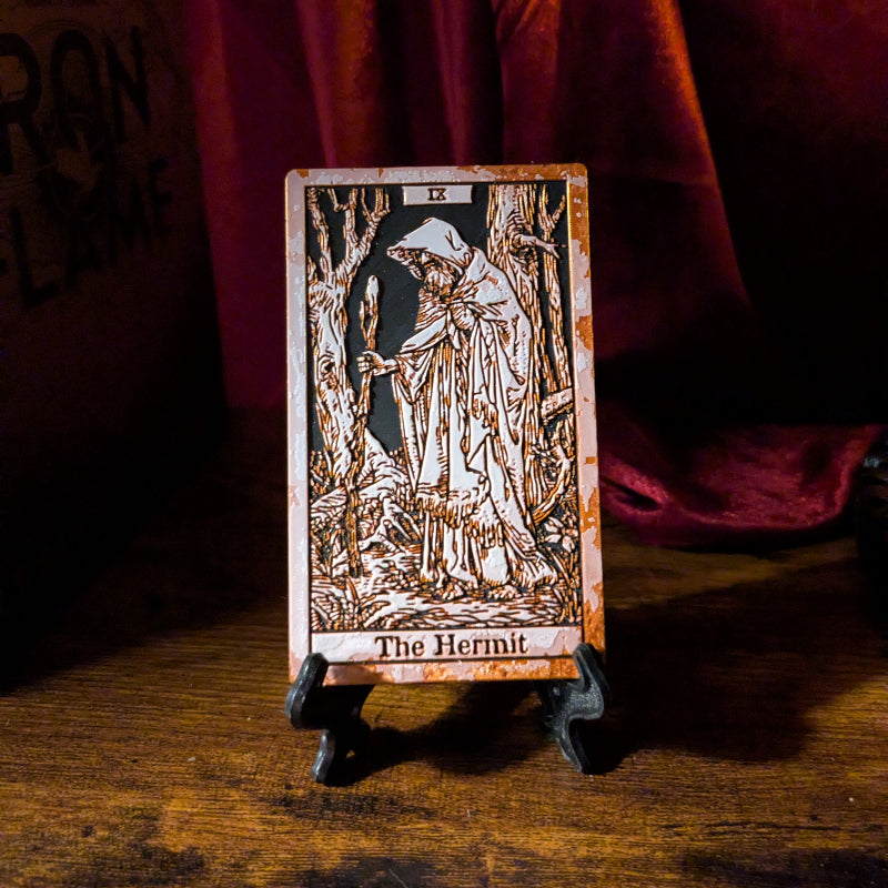 The Hermit tarot bookmark, Collector Edition, shown upright on a small black stand with a copper-toned border and raised relief artwork