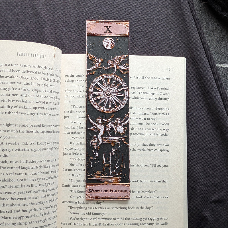 Classic Edition Wheel of Fortune tarot bookmark displayed vertically over an open book